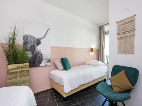 une chambre avec un lit et une chaise dedans dans l'établissement Apartment in Julianadorp near the Beach, à Julianadorp