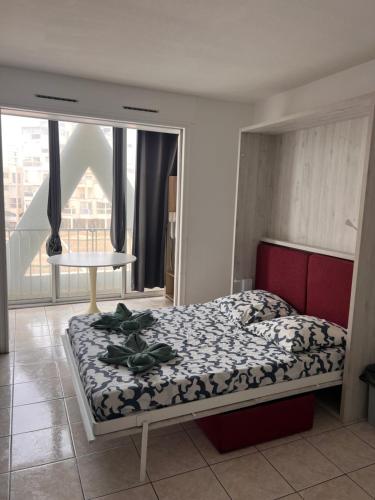 une chambre avec un lit et une grande fenêtre dans l'établissement La Cachette 70 et 139, à La Grande Motte