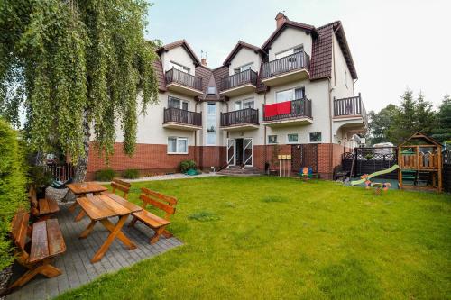 a building with a picnic table and benches in the yard at Nord Jastarnia bis in Jastarnia