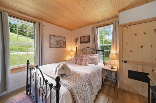 ein Schlafzimmer mit einem Bett, auf dem ein Stofftier liegt in der Unterkunft Broadstone Cottage in Banner Elk