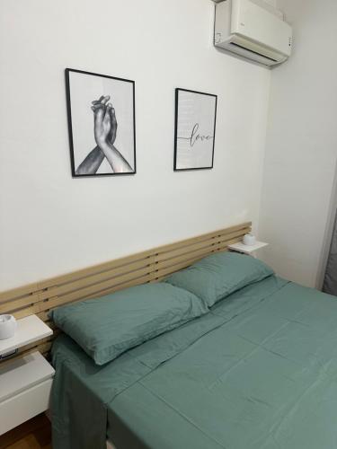 a bedroom with a green bed and two pictures on the wall at Moderno apartamento en pueblo tranquilo Navàs Barcelona in Navás