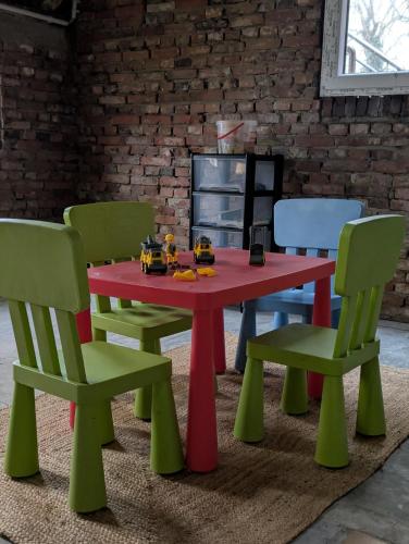 a red table and chairs with toy cars on it at Traumkrone Ferienwohnungen - Himmelblau in Schortens