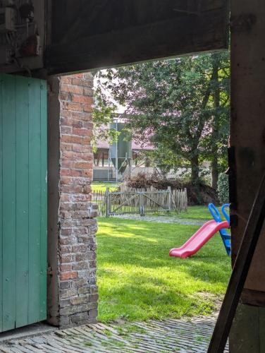 a view of a yard with a playground with a pink slide at Traumkrone Ferienwohnungen - Himmelblau in Schortens