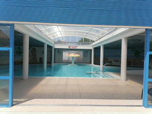 une grande piscine dans un bâtiment avec un plafond dans l'établissement Mobil-home bord de plage à Saint-Hilaire-de-Riez, à Saint-Hilaire-de-Riez