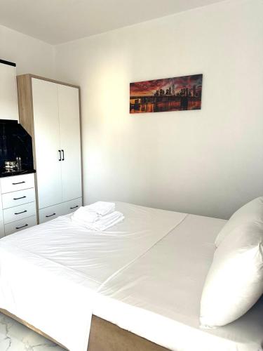 a bedroom with a white bed and a mirror at Taku Rooms Vlora 3 in Vlorë