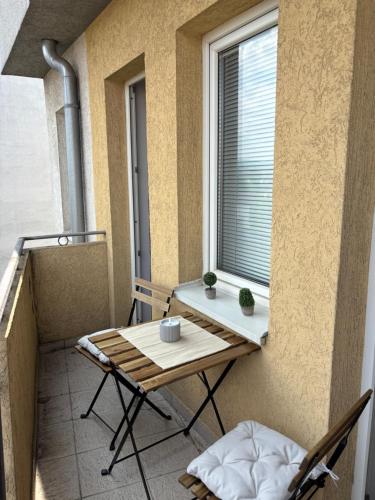ein kleiner Balkon mit Tisch und Fenster in der Unterkunft Apartman Centar VV in Kragujevac