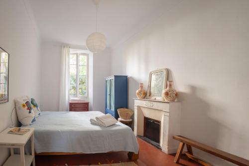 une chambre blanche avec un lit et une cheminée dans l'établissement GRASSE Charming Spacious Apt in Heart of City, à Grasse