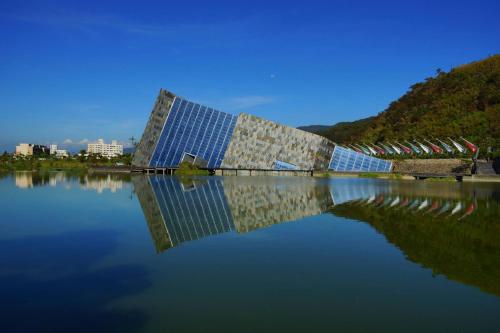a building sitting on top of a body of water at Every Day Hot Spring Hotel in Jiaoxi