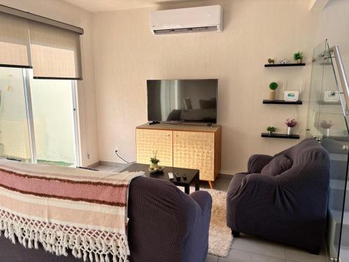 a living room with two chairs and a television at Casa ensueño in Los Algodones