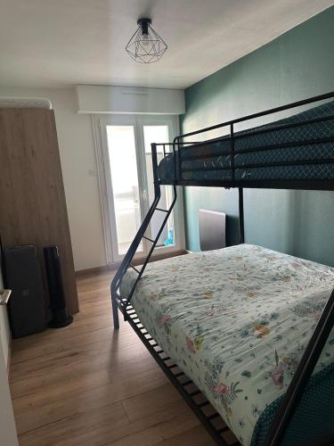 - une chambre avec des lits superposés et une couette dans l'établissement Appartement 50m de la plage Saint Hilaire de Riez, à Saint-Hilaire-de-Riez