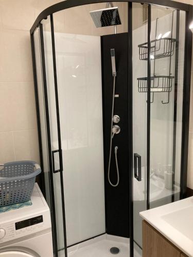 une douche avec une porte vitrée dans une salle de bain dans l'établissement Appartement 50m de la plage Saint Hilaire de Riez, à Saint-Hilaire-de-Riez