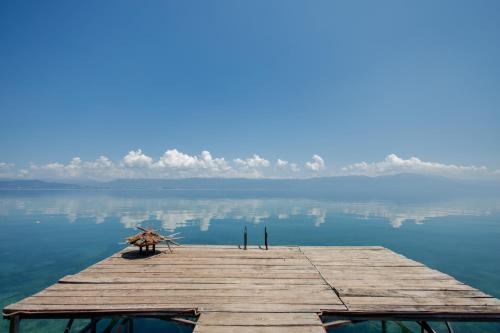 a wooden dock in the middle of the water at Vila Kladenci in Radožda