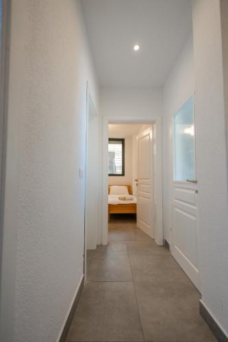 a hallway with white walls and a room with a bed at Vila Kladenci in Radožda