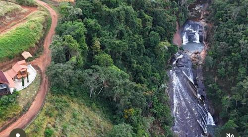 an aerial view of a waterfall in a forest at chalecachoeiradochiador in Espera Feliz
