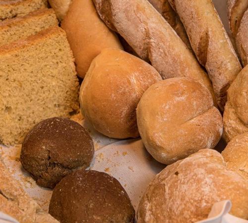 a pile of different types of bread on a table at Hotel Florença in Talatona