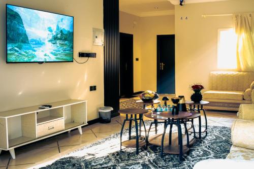 a living room with a tv on the wall at شاليهات نوافل الذهبية GOLDEN NAWAFEL chalets in Al Hada