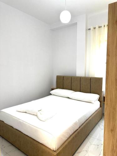 a bedroom with a bed with white sheets and pillows at Taku Rooms Vlora 2 in Vlorë