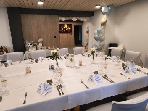 a table with white table cloths and vases with flowers at Salatín in Ružomberok