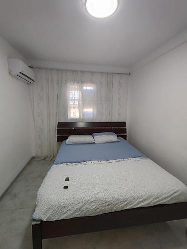 a bedroom with a bed in a room with a window at Apartments by the beach 60-6 in Qiryat H̱ayyim