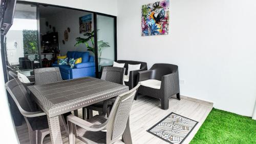 a dining table and chairs in a living room at Macaw House with private pool in Arenas Herradura in Herradura