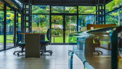 a room with chairs and tables and windows at Macaw House with private pool in Arenas Herradura in Herradura