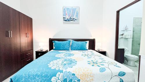 a bedroom with a bed with a blue and white bedspread at Macaw House with private pool in Arenas Herradura in Herradura