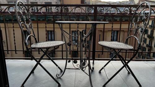 two chairs and a table on a balcony at La Corte di Partenope Luxury Suite in Naples