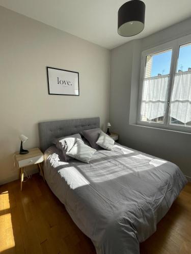 - une chambre dotée d'un lit avec un signe d'amour sur le mur dans l'établissement Tours Hyper center apartment, à Tours