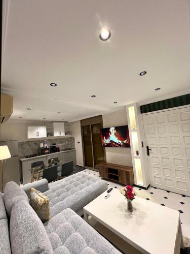 a living room with a couch and a tv at Villa 3 Corniche, Charming Seaside Villa with Jacuzzi, Carrousel Mall Rabat in Rabat