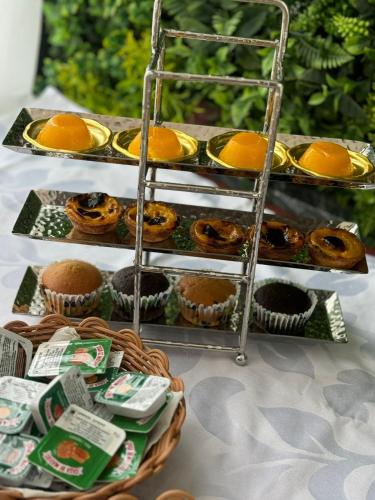 a display of muffins and cupcakes on a shelf at Hotel Florença in Talatona