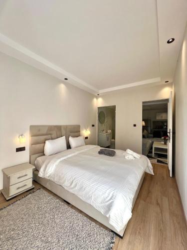 a white bedroom with a large white bed and a rug at Villa 3 Corniche, Charming Seaside Villa with Jacuzzi, Carrousel Mall Rabat in Rabat