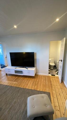 a living room with a large flat screen tv at Little red house located 400m from university in Örebro in Örebro