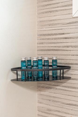 a shelf with blue paint bottles on a wall at Casa Giardino in Livadi Astypalaias