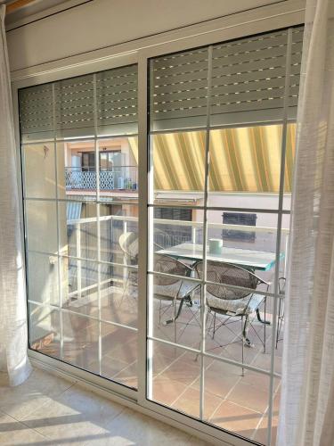 a room with sliding glass doors with a table and chairs at Casa Sant Antoni in Calonge