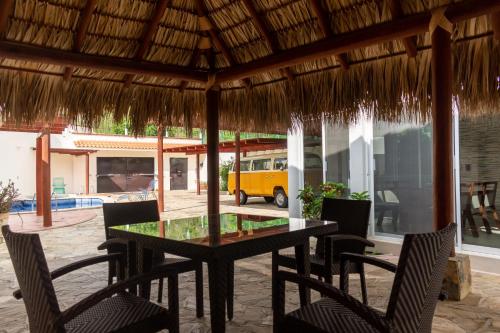 a table and chairs in a patio with a yellow van at Casa colibrí in Tangolunda