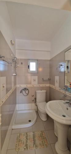 un bagno bianco con un water e un lavandino di Villa Violeta a Ksamil