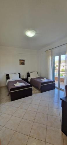 due letti in una stanza con una stanza con finestre di Villa Violeta a Ksamil