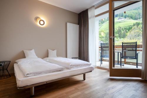 a bedroom with a bed and a sliding glass door at Residenz Feldmühle unterhalb der Burg Taufers in Campo Tures