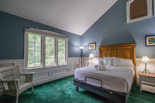 a bedroom with blue walls and a bed and a chair at Historic 4BR Colonial with Pool Table and Fire Pit in Hendersonville