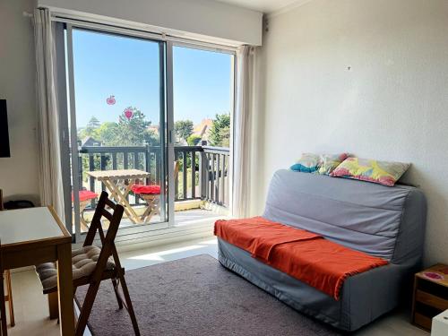 Cette chambre dispose d'un lit en face d'une fenêtre. dans l'établissement T2 Logement entier, balcon, piscine, tennis et accès direct à la plage!, à Cabourg