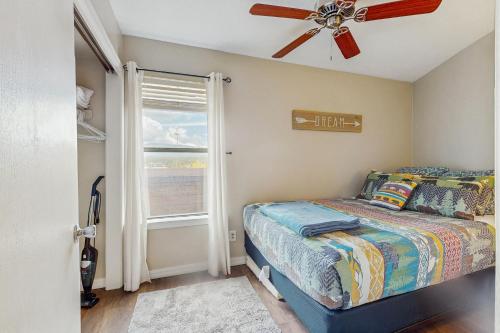 a bedroom with a bed with a ceiling fan and a window at Christi Villa 100 in Angel Fire