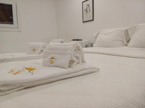 two white beds with towels on top of them at Boa Ventura Home in Porto