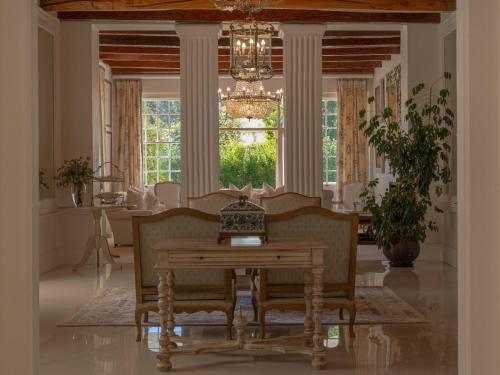 a dining room with a table and chairs and a chandelier at The Doolhof Country House in Wellington