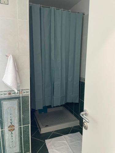 a shower with a blue shower curtain in a bathroom at Glory's Apartments Sarande in Sarandë