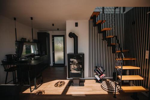 a living room with a spiral staircase and a piano at Warmiński Sad in Olsztyn