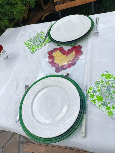 a table with white plates on a white table cloth at Une bulle de bien être au rendez vous in Pexiora