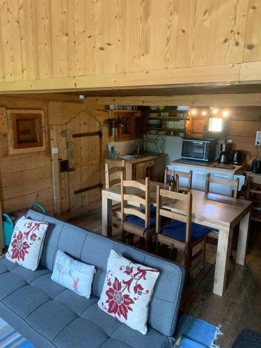 un salon avec un canapé et une table et une cuisine dans l'établissement Mazot Hirondelle, à Morzine