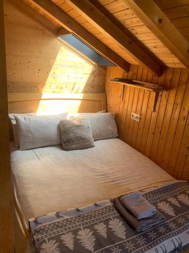 Ce lit se trouve dans une cabane en bois dotée d'une fenêtre. dans l'établissement Mazot Hirondelle, à Morzine