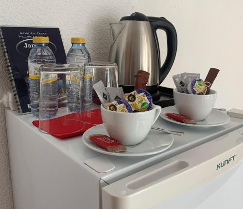 a white cabinet with two cups and a tea kettle at Casa Don Juan in Benidorm