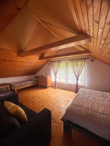 a large room with a bed and a window at Chata Roda s vnitřní saunou in Rabyně